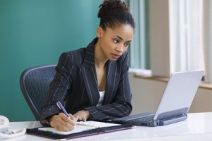 Businesswoman taking notes at her desk